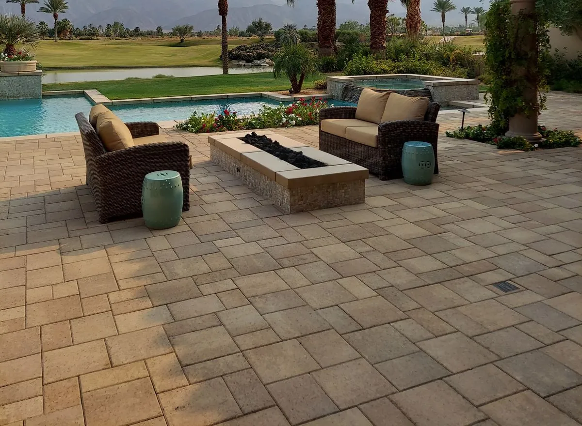 Sealed concrete paver pool deck with patio furniture beside the pool