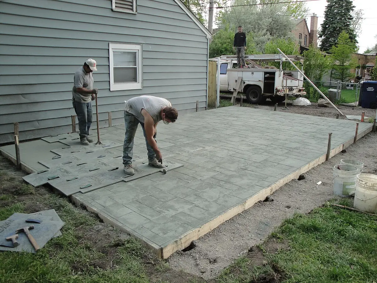 Fresh concrete being placed and finished for a new pool deck