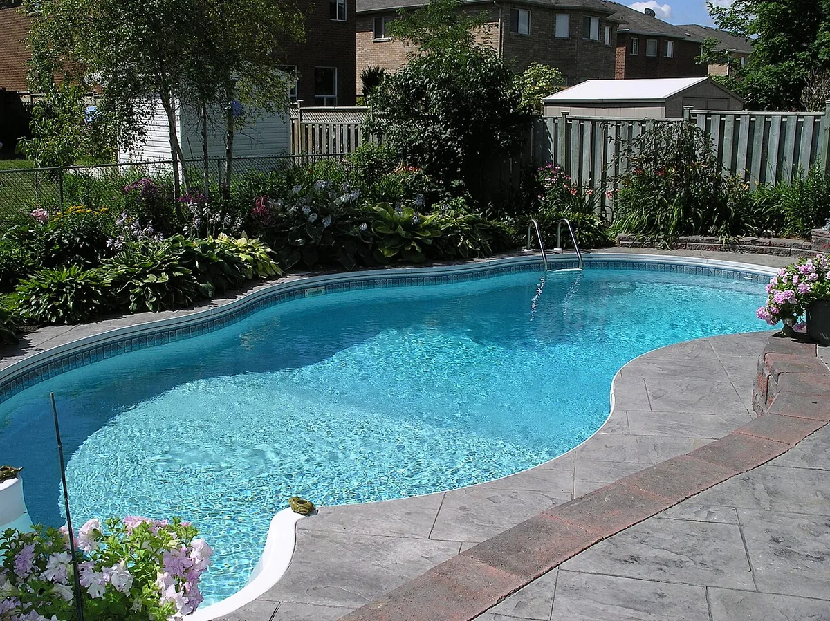 Stamped concrete overlay pattern on a pool deck with a darker stamped border band at the pool edge