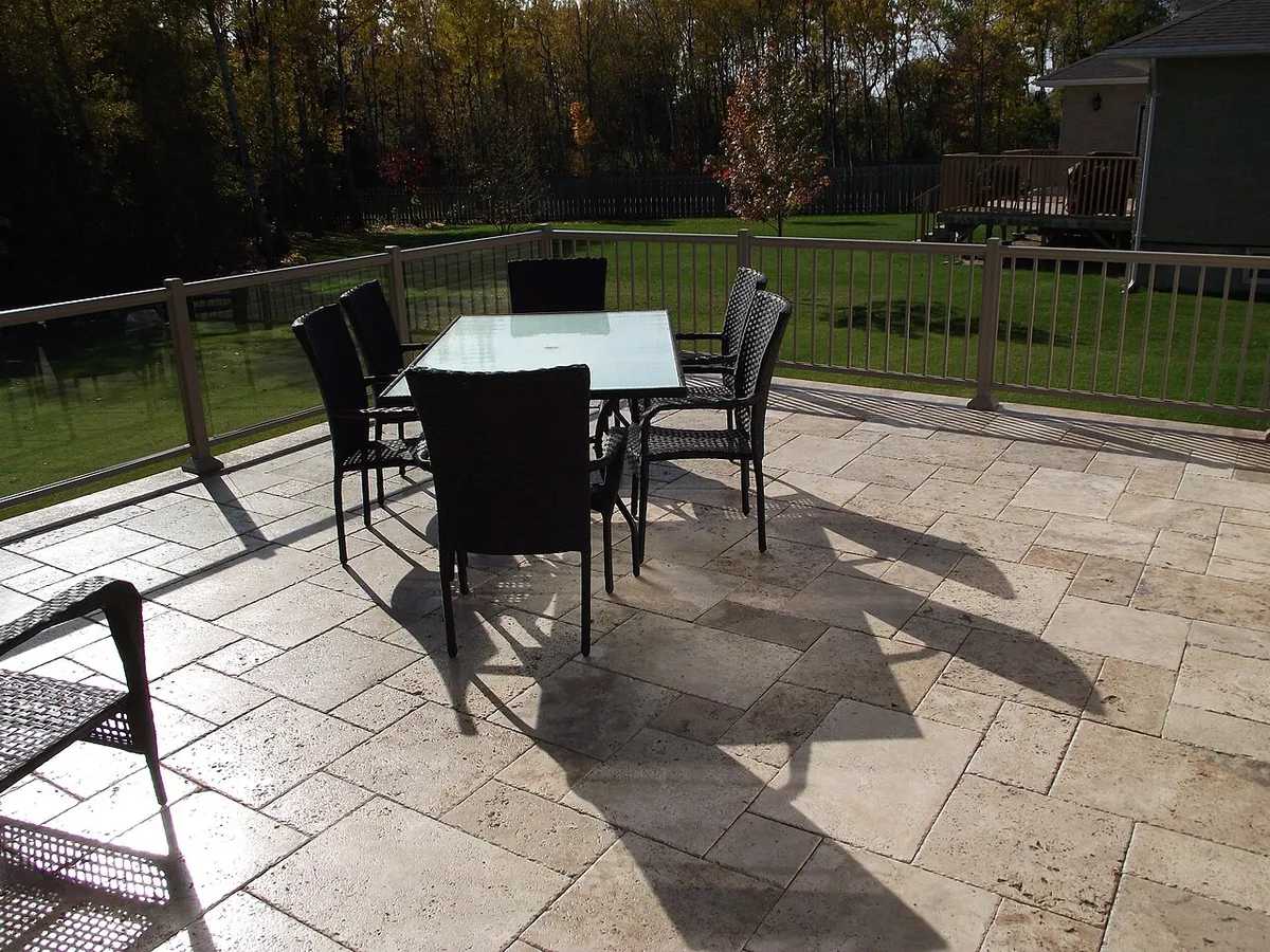 Ivory travertine pavers in a French pattern on a backyard deck